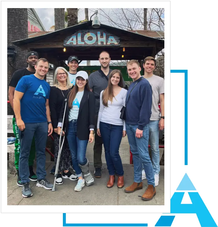 A group of people standing in front of an umbrella.